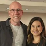 A high-quality professional indoor portrait of Beata Galloway smiling alongside a colleague.