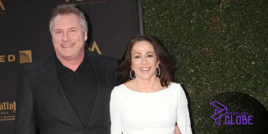 Constantine Yankoglu smiling with his partner at a formal Hollywood red carpet event.