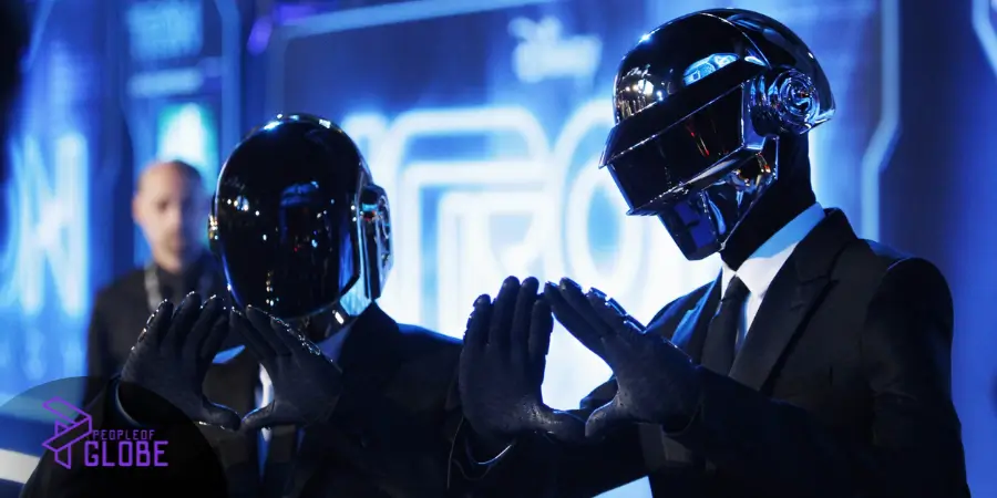 Daft Punk performing live inside their famous neon pyramid stage setup surrounded by custom electronic instruments.