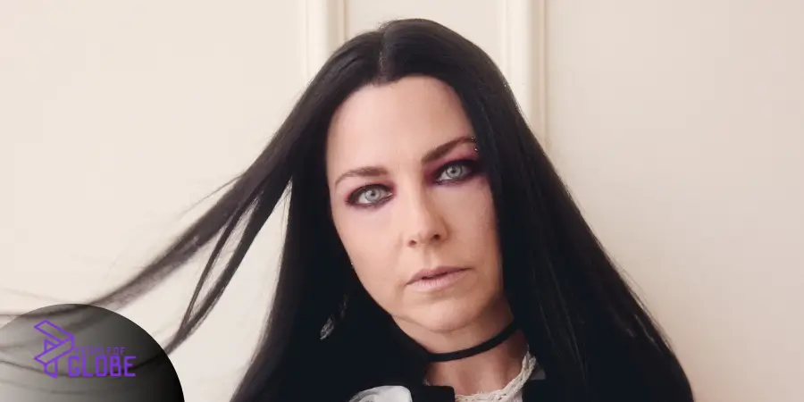A professional portrait of Amy Lee with long black hair, wearing a stylish dark outfit.