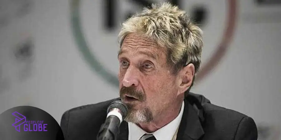 John McAfee speaking dynamically at a global blockchain event, highlighting his transition into digital currency.