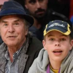 Don Johnson and his young son, Jasper Breckenridge Johnson, sitting courtside at a basketball game.
