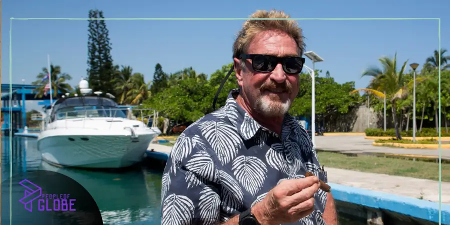Tech entrepreneur John McAfee smiling at a public tech conference, representing the foundation of his career.