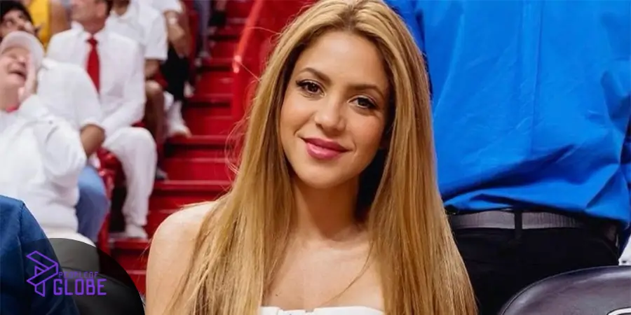 A high-quality portrait of Colombian singer Shakira, sister of Patricia Mebarak, smiling at a sports stadium.