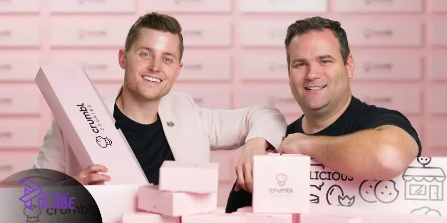 Sawyer Hemsley and a colleague posing with signature pink Crumbl Cookies packaging.